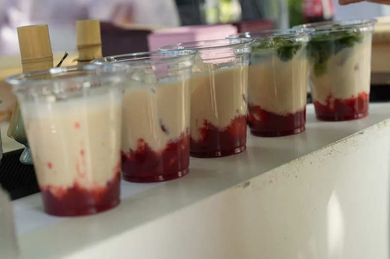 Eine Reihe fertiger Matcha Drinks mit Fruchtpüree auf der Femio Bar