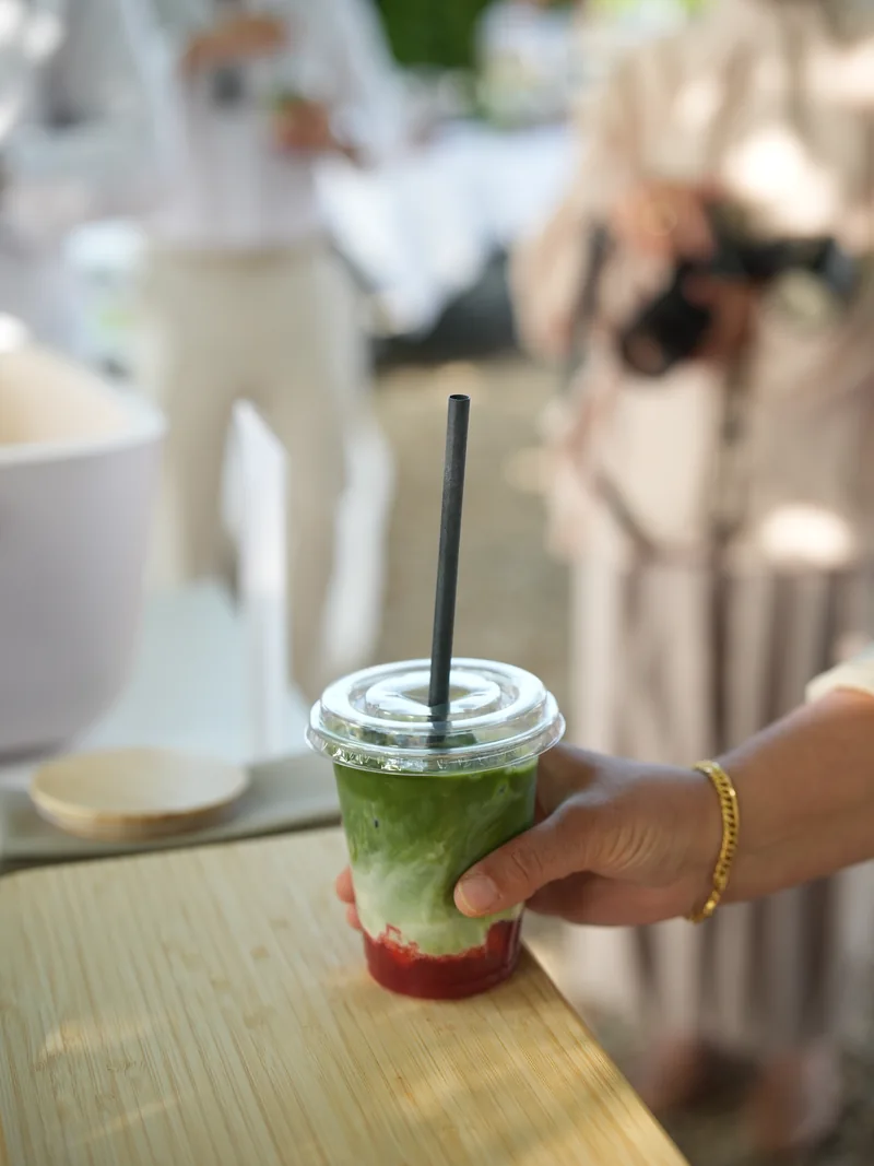 Ein fertiger Matcha Drink wird über die Bar gereicht