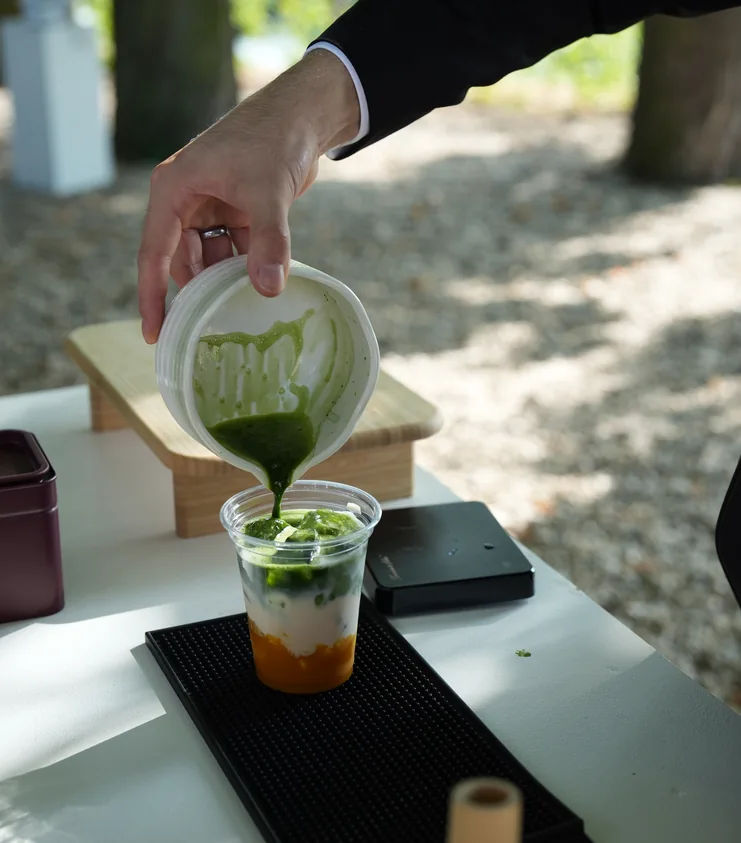Frisch aufgeschlagener Matcha wird an der Femio Bar über die Fruchtschicht gegossen
