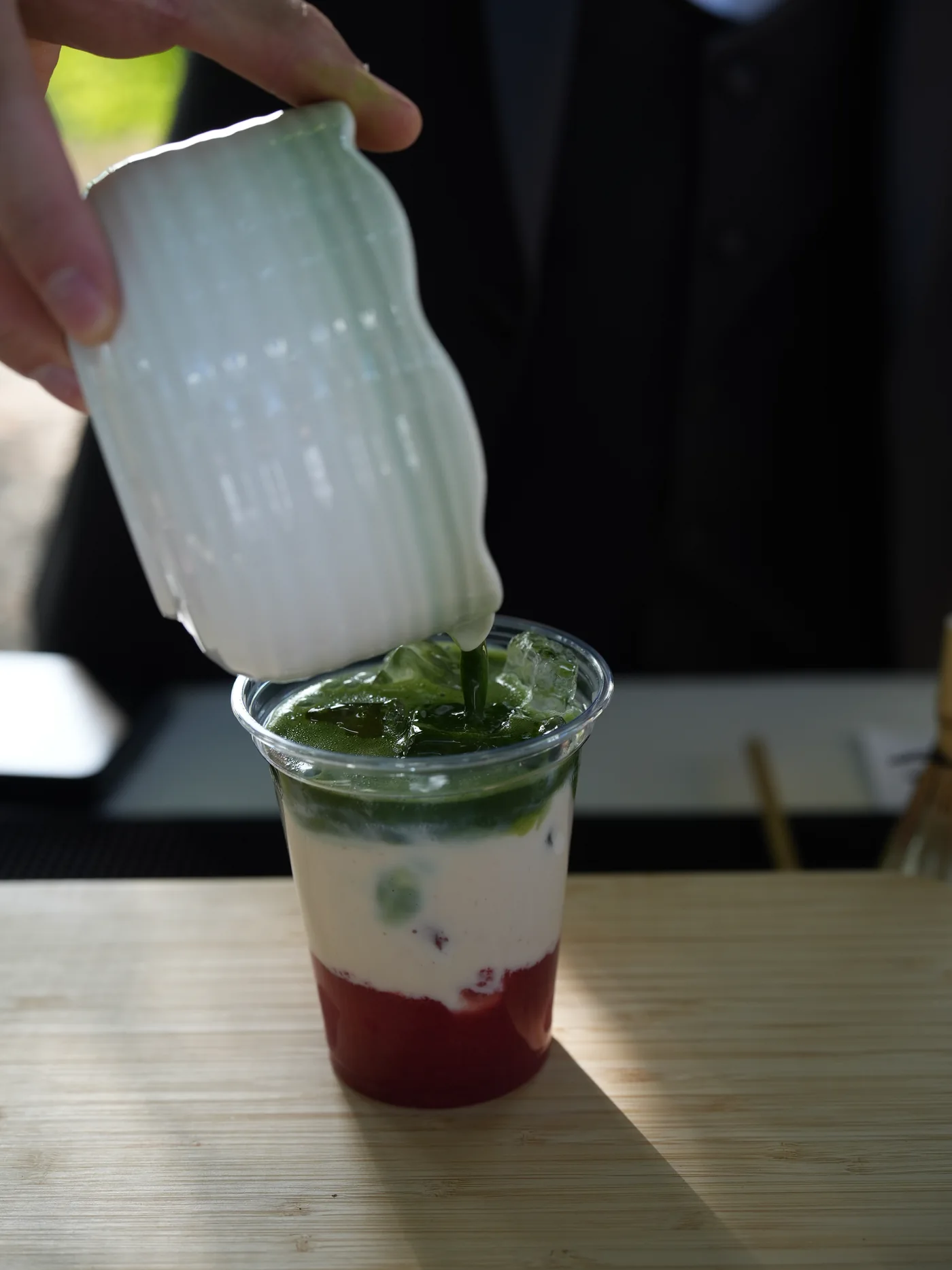 Frische Milch wird über den aufgeschlagenen Matcha gegossen